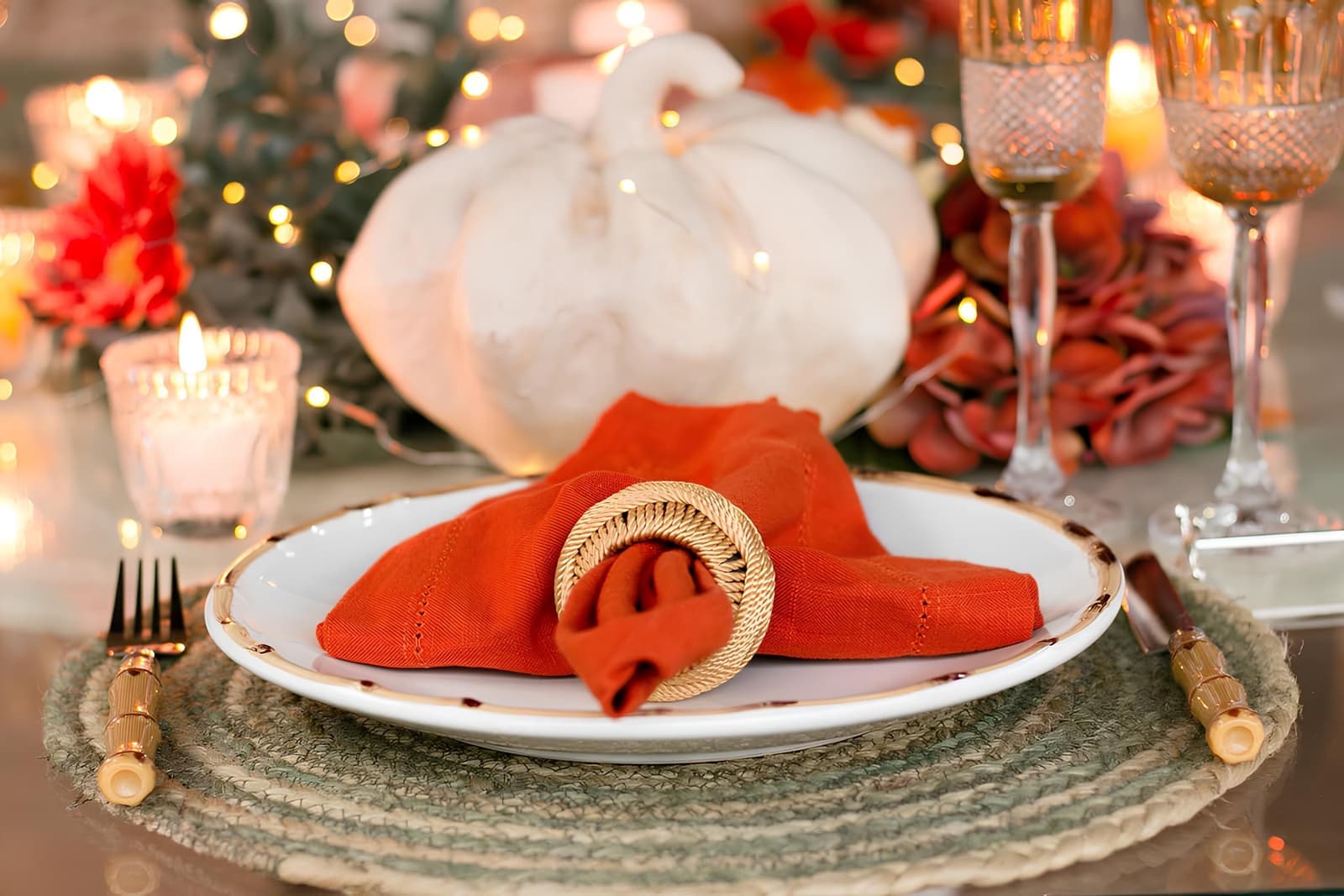 An autumn table setting with pumpkins and warm candlelight