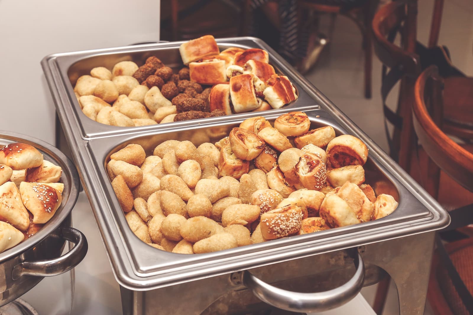 Dishes of food held warm on a buffet serving surface